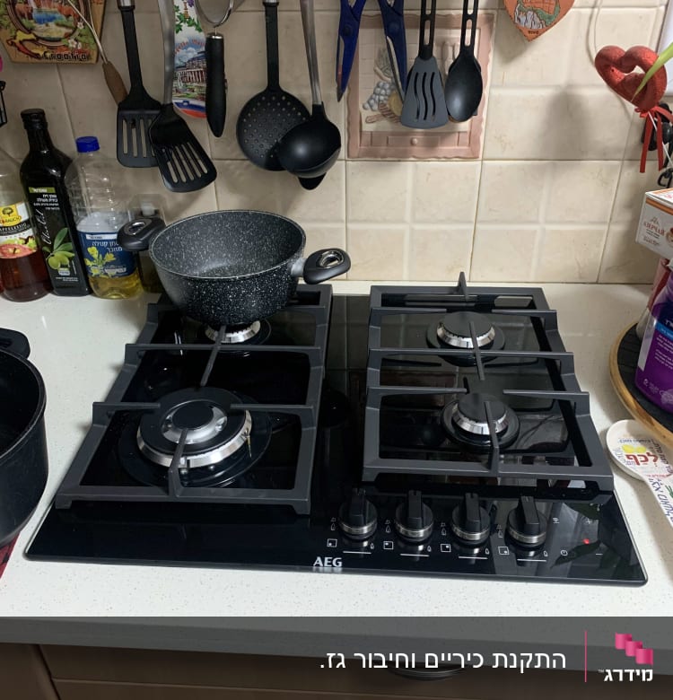 כיריים גז עם סירים וכלי מטבח תלויים